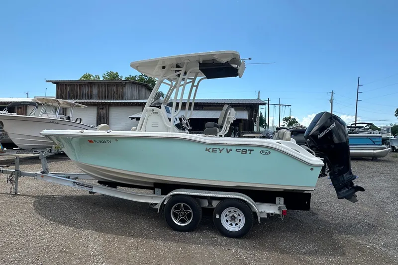 Slide: The Image of 2025 Key West 219 FS boat on trailer, parked outdoors under clear sky. - 2