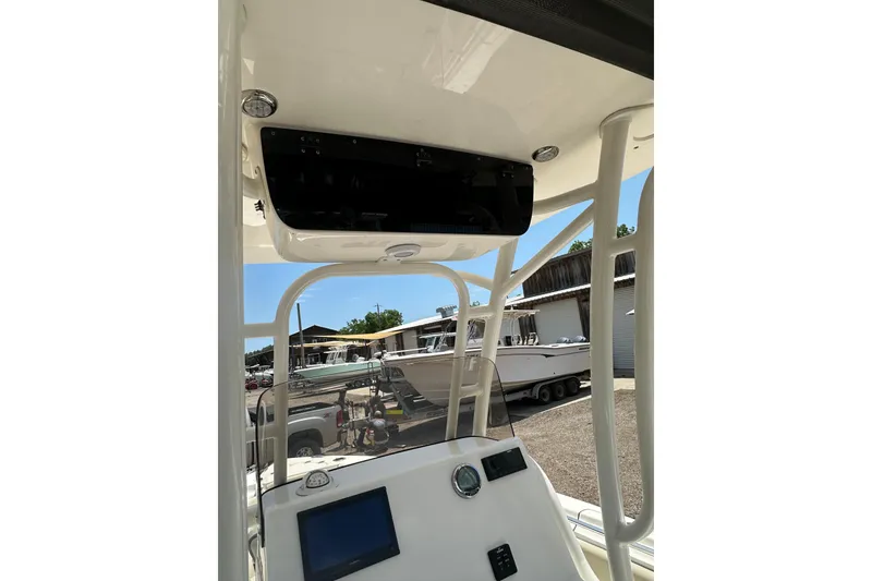 Slide: The Image of 2025 Key West 219 FS boat console with electronics, docked in a marina under clear skies. - 26
