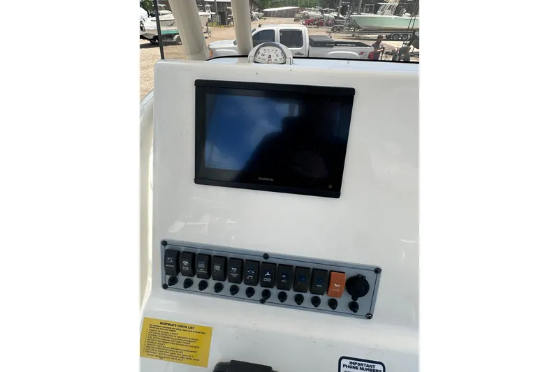 Slide: The Image of 2025 Key West 219 FS boat dashboard with Garmin display and control panel. - 28