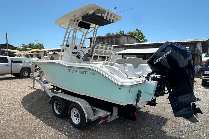 Slide: The Image of 2025 Key West 219 FS boat on trailer with Mercury outboard motor in a sunny yard. - 3