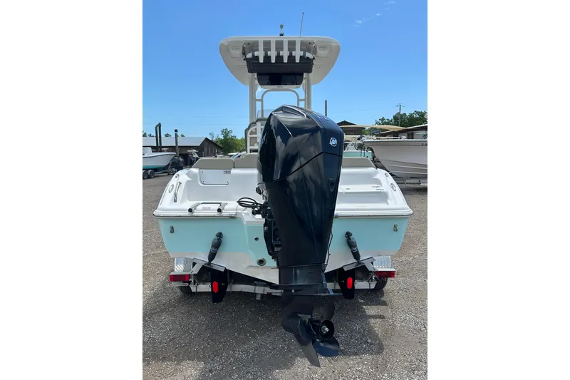 Slide: The Image of 2025 Key West 219 FS boat with powerful outboard motor, parked on gravel. - 4