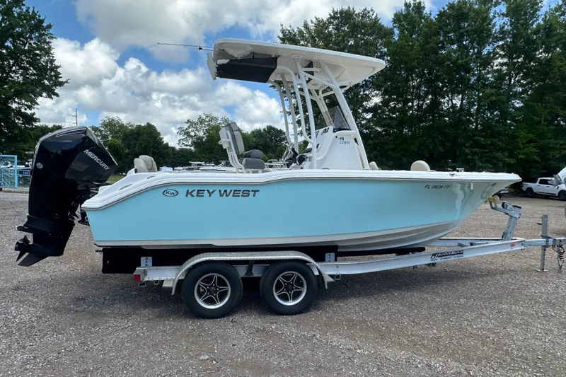 Slide: The Image of 2025 Key West 219 FS boat on trailer, parked outdoors under cloudy sky. - 6