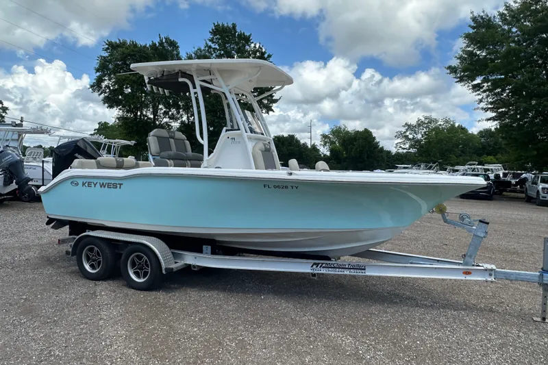 Slide: The Image of 2025 Key West 219 FS boat on trailer, parked outdoors under cloudy sky. - 7