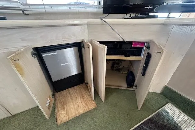 Slide: The Image of 1994 Tollycraft 45 Cockpit Motor Yacht interior with open cabinets and mini fridge. - 21