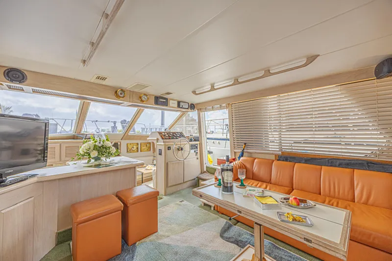 Slide: The Image of Luxurious interior of 1994 Tollycraft 45 Cockpit Motor Yacht with orange seating and helm. - 23