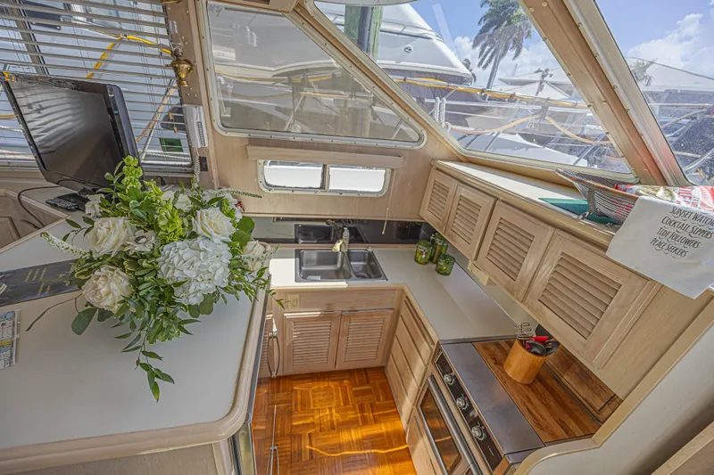 Slide: The Image of Interior of 1994 Tollycraft 45 Cockpit Motor Yacht with kitchen and floral arrangement. - 27