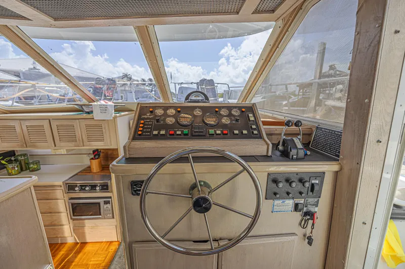 Slide: The Image of 1994 Tollycraft 45 Cockpit Motor Yacht helm with steering wheel and control panel. - 30