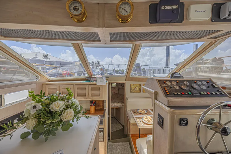 Slide: The Image of Interior of 1994 Tollycraft 45 Cockpit Motor Yacht with helm, floral arrangement, and navigation equipment. - 31