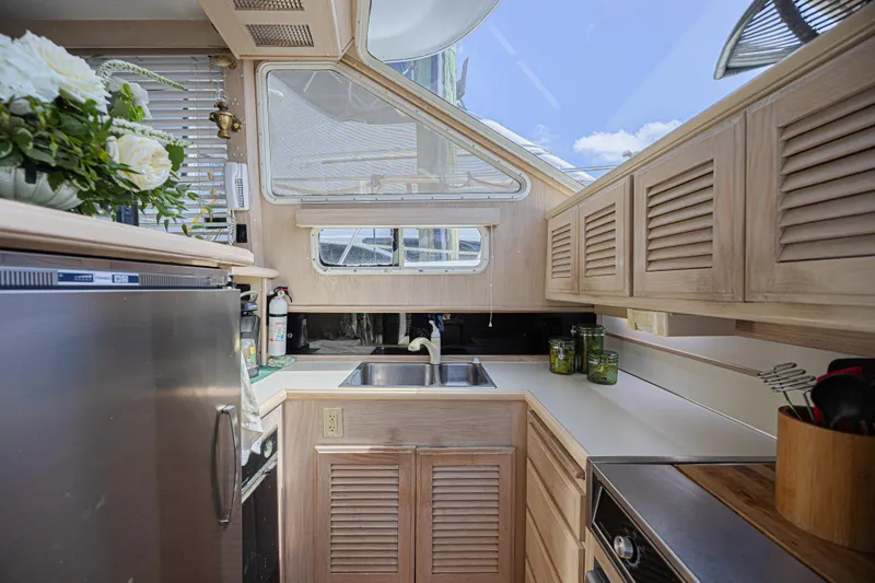 Slide: The Image of Interior of 1994 Tollycraft 45 Cockpit Motor Yacht kitchen with sink and cabinets. - 32