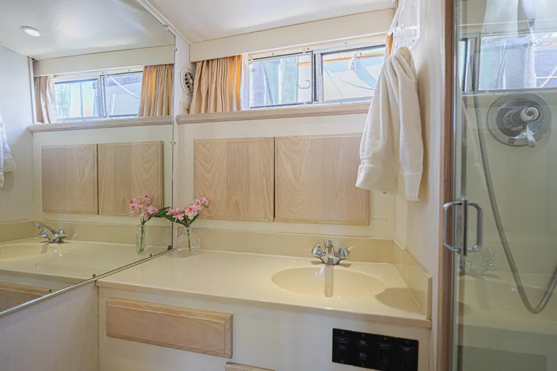 Slide: The Image of Luxurious bathroom in 1994 Tollycraft 45 Cockpit Motor Yacht with dual sinks and floral decor. - 42