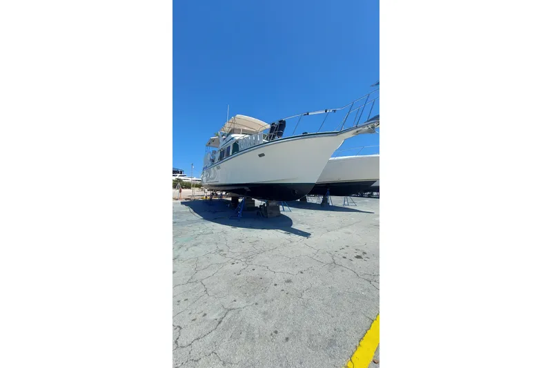Slide: The Image of 1994 Tollycraft 45 Cockpit Motor Yacht on dry dock under clear blue sky. - 50