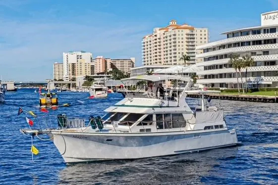 Slide: The Image of 1994 Tollycraft 45 Cockpit Motor Yacht cruising in a vibrant waterfront cityscape. - 53