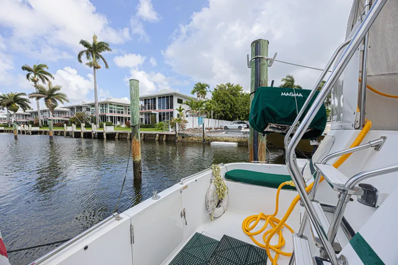 Slide: The Image of 1994 Tollycraft 45 Cockpit Motor Yacht docked near waterfront homes and palm trees. - 7