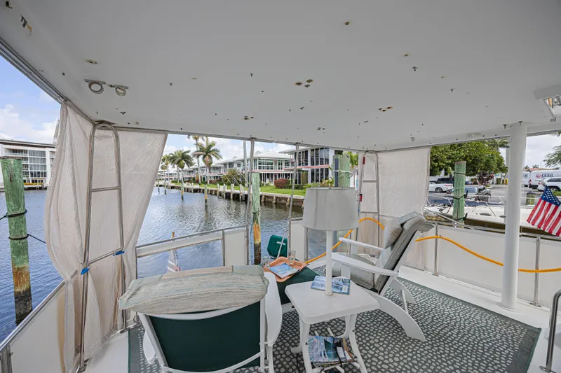Slide: The Image of 1994 Tollycraft 45 Cockpit Motor Yacht interior with waterfront view and seating area. - 8