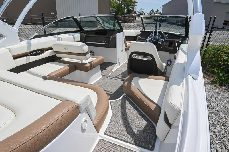 Slide: The Image of 2022 Cobalt CS22 boat interior with white and brown seating, modern dashboard, and open layout. - 18