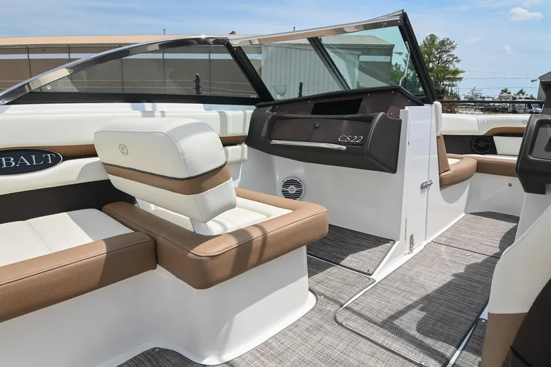 Slide: The Image of 2022 Cobalt CS22 boat interior with beige and white seating, modern dashboard, and open cockpit. - 28
