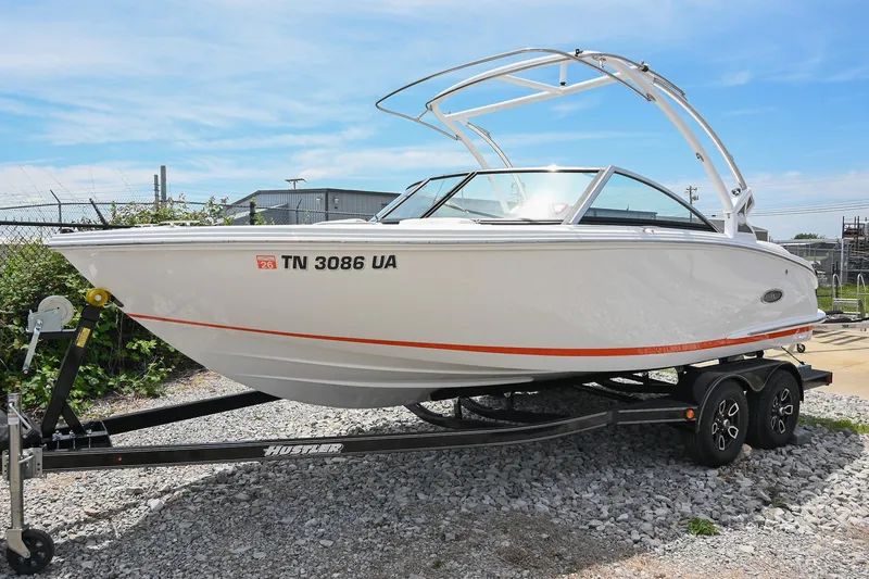 Slide: The Image of 2022 Cobalt CS22 boat on trailer, white with orange stripe, parked outdoors. - 4