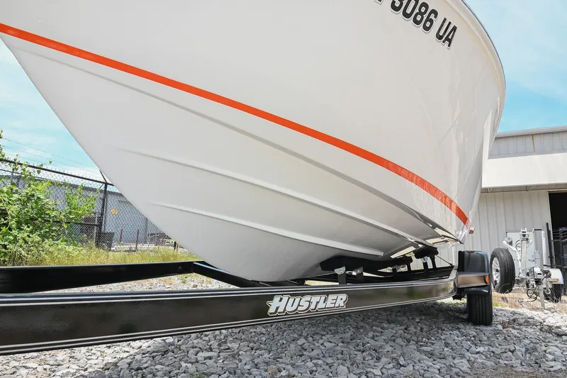 Slide: The Image of 2022 Cobalt CS22 boat on Hustler trailer, parked on gravel near a building. - 48