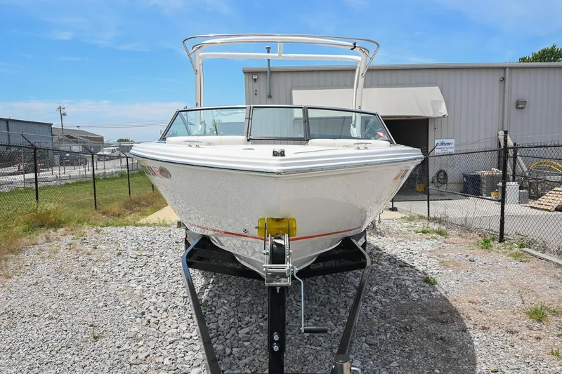 Slide: The Image of 2022 Cobalt CS22 boat on trailer, parked outdoors near industrial building. - 6