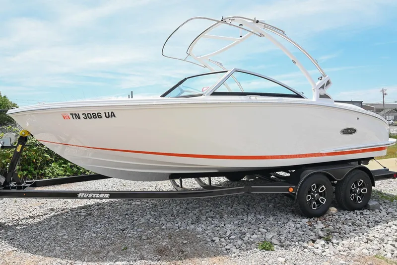 Slide: The Image of 2022 Cobalt CS22 boat on trailer, white with orange stripe, parked on gravel. - 8
