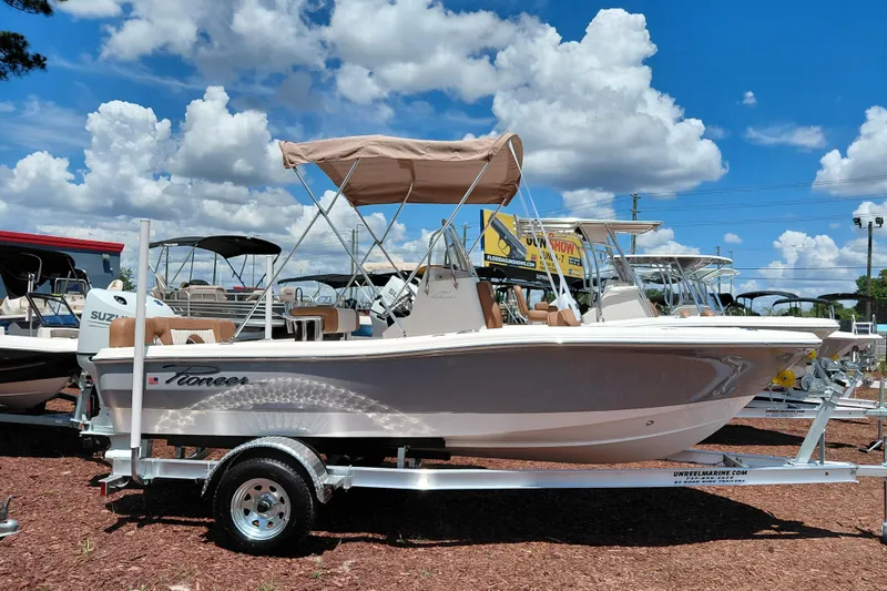The Image of 2026 Pioneer 180 Islander boat on trailer under blue sky with clouds. - 1