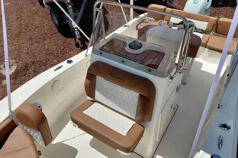 Slide: The Image of 2026 Pioneer 180 Islander boat interior with tan and white seating, console, and steering wheel. - 11
