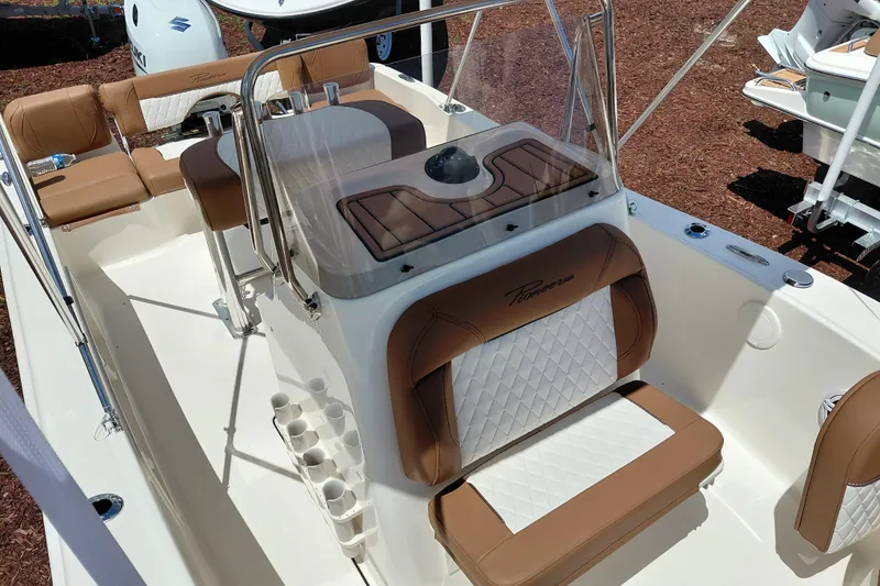 Slide: The Image of 2026 Pioneer 180 Islander boat interior with tan and white seating, sleek design. - 12