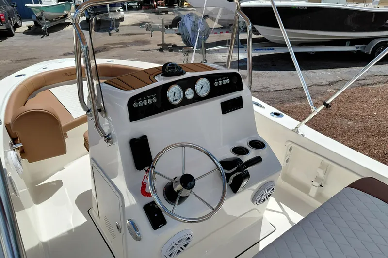Slide: The Image of 2026 Pioneer 180 Islander boat interior with steering console and seating. - 14