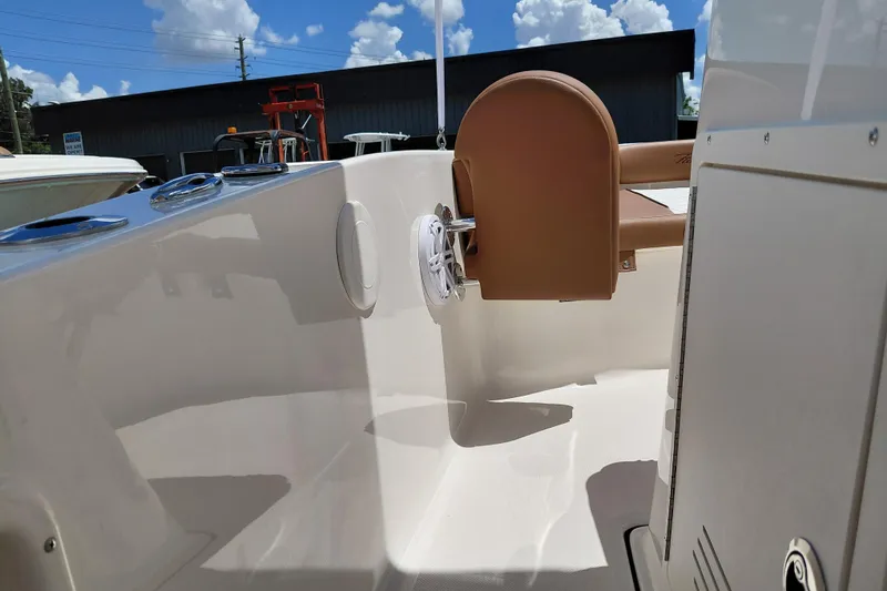 Slide: The Image of 2026 Pioneer 180 Islander boat interior with seating and storage, under a clear blue sky. - 17