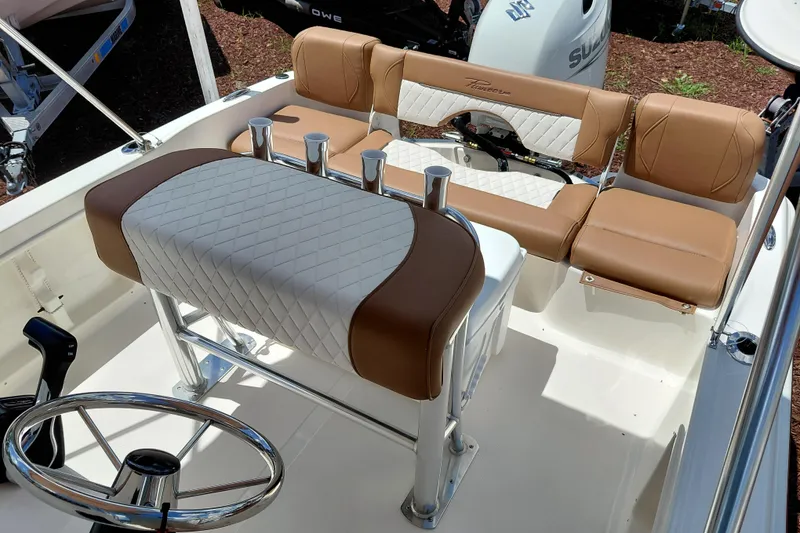Slide: The Image of 2026 Pioneer 180 Islander boat interior with tan and white seating, steering wheel, and rod holders. - 18