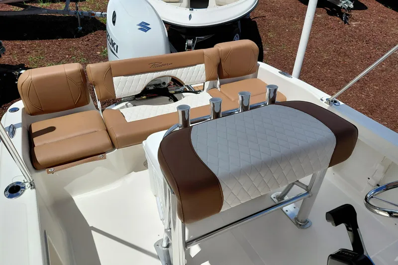 Slide: The Image of 2026 Pioneer 180 Islander boat interior with tan and white seating, featuring a Suzuki engine. - 19