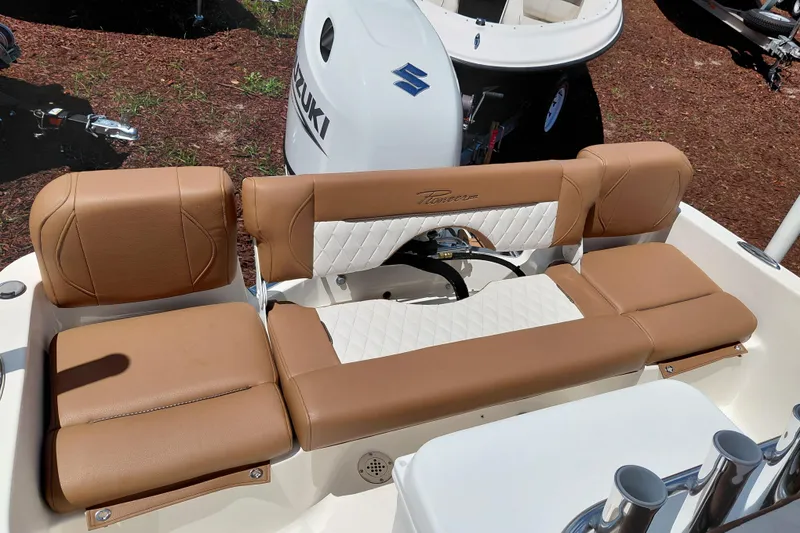 Slide: The Image of 2026 Pioneer 180 Islander boat with tan leather seating and Suzuki outboard motor. - 21