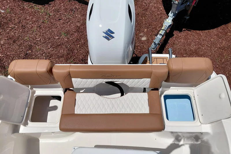 Slide: The Image of 2026 Pioneer 180 Islander boat interior with tan and white seating, Suzuki engine visible. - 27