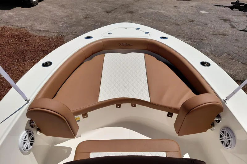 Slide: The Image of 2026 Pioneer 180 Islander boat with tan cushioned seating and white diamond-patterned upholstery. - 30