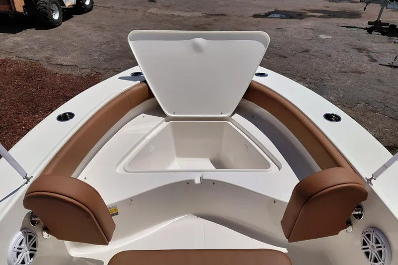 Slide: The Image of 2026 Pioneer 180 Islander boat interior with open storage compartment and brown seating. - 32