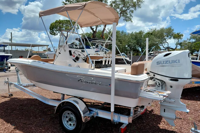 Slide: The Image of 2026 Pioneer 180 Islander boat with Suzuki engine on trailer, under sunny skies. - 5