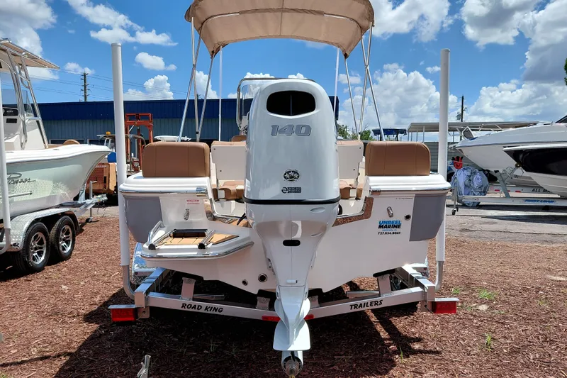 Slide: The Image of 2026 Pioneer 180 Islander boat with 140 HP engine on trailer under blue sky. - 6