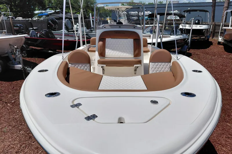 Slide: The Image of 2026 Pioneer 180 Islander boat with tan and white seating, displayed outdoors. - 8