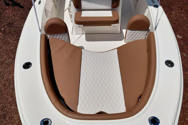 Slide: The Image of 2026 Pioneer 180 Islander boat interior with brown and white cushioned seating. - 9