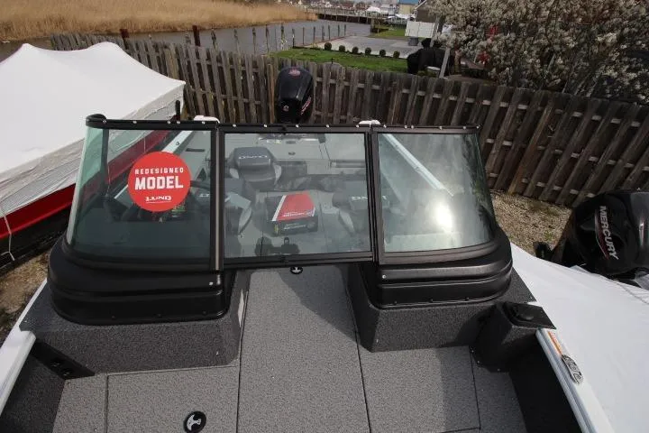 Slide: The Image of 2025 Lund 1775 Impact XS Sport boat with redesigned model features, docked outdoors. - 5