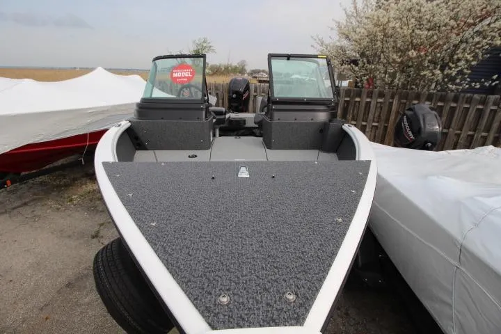 Slide: The Image of 2025 Lund 1775 Impact XS Sport boat, front view, parked outdoors. - 7