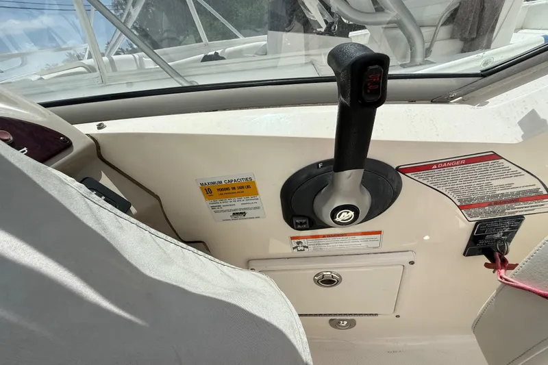 Slide: The Image of Control panel of a 2010 Sea Ray 240 Sundancer boat with throttle and safety warnings. - 16
