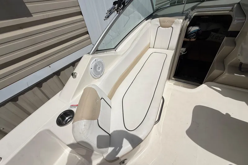 Slide: The Image of 2010 Sea Ray 240 Sundancer boat interior with white seating and speaker. - 18