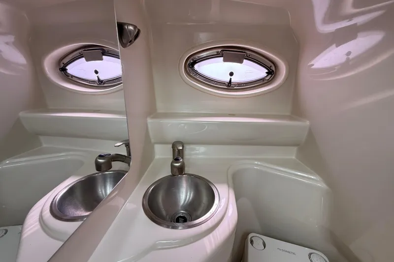 Slide: The Image of Compact bathroom in 2010 Sea Ray 240 Sundancer boat with sink and porthole window. - 20