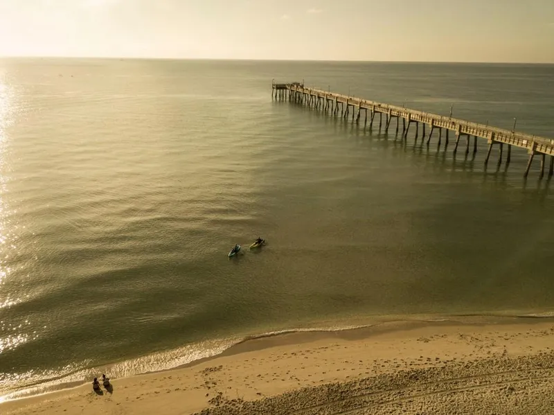 Slide: The Image of Aerial view of kayakers near a pier on a calm ocean at sunset. - 9