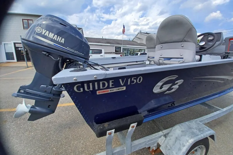 Slide: The Image of 2021 G3 Guide V150 T boat with Yamaha motor on trailer, parked outdoors. - 3
