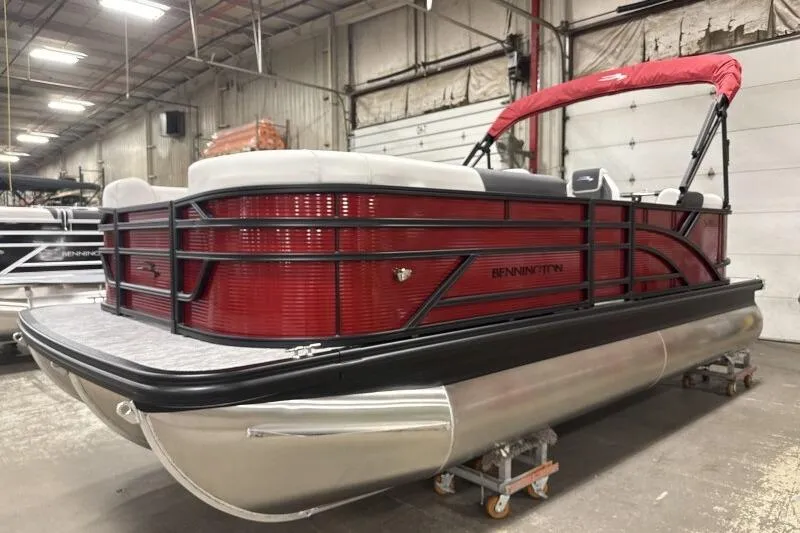 Slide: The Image of 2026 Bennington S 20 SSR pontoon boat with red exterior in a warehouse setting. - 11