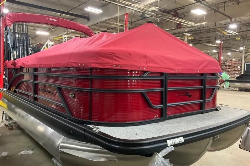 Slide: The Image of 2026 Bennington S 20 SSR pontoon boat with red cover in a warehouse setting. - 26