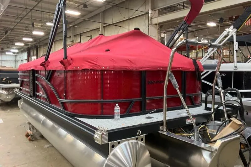 Slide: The Image of 2026 Bennington S 20 SSR pontoon boat with red cover in a warehouse setting. - 28