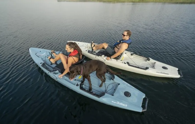 The Image of Two people kayaking with a dog on Hobie Outback kayaks, 2023 model. - 0